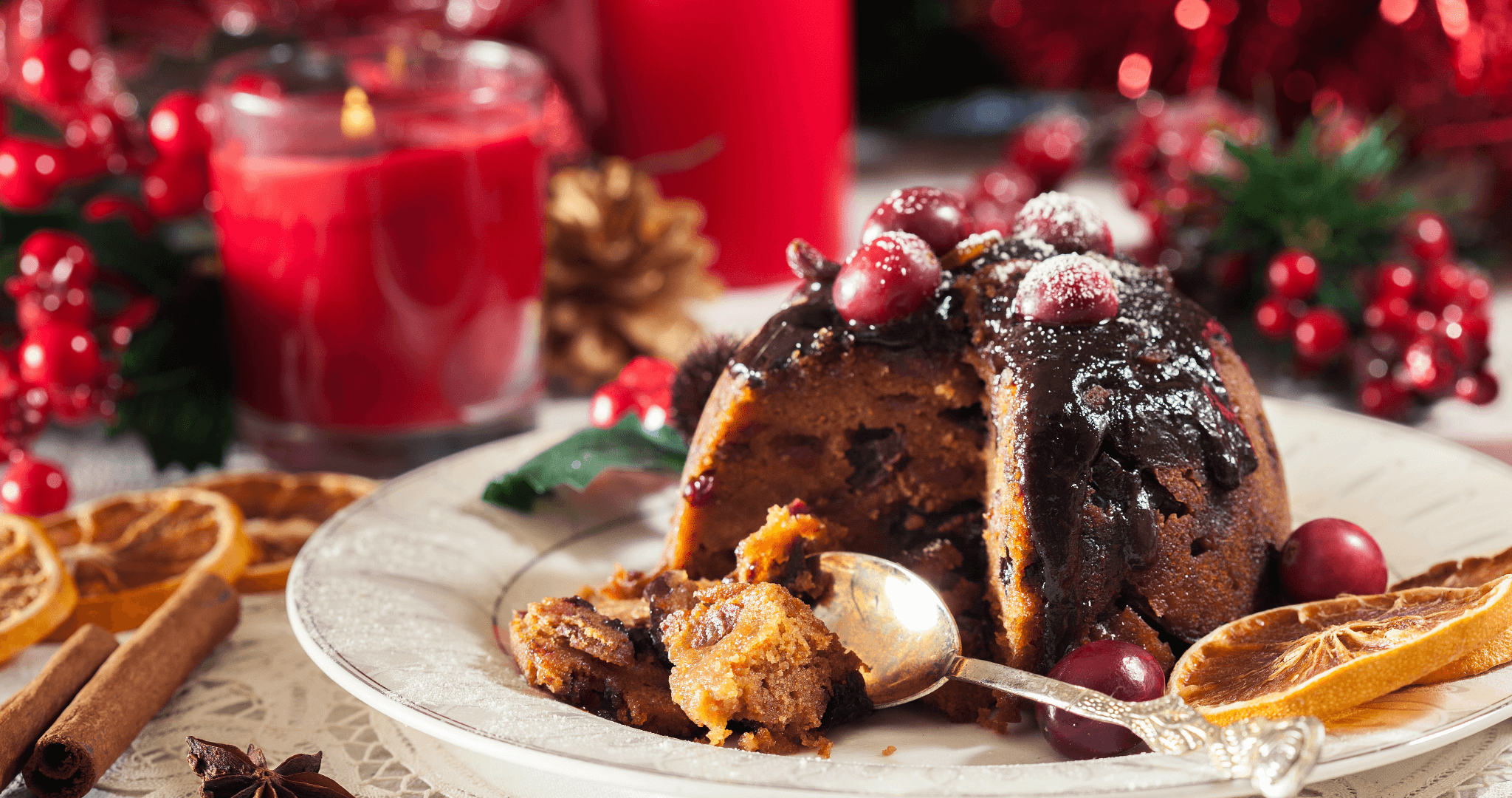 a lovely Christmas pudding with a slice taken out of it with a red festive background.