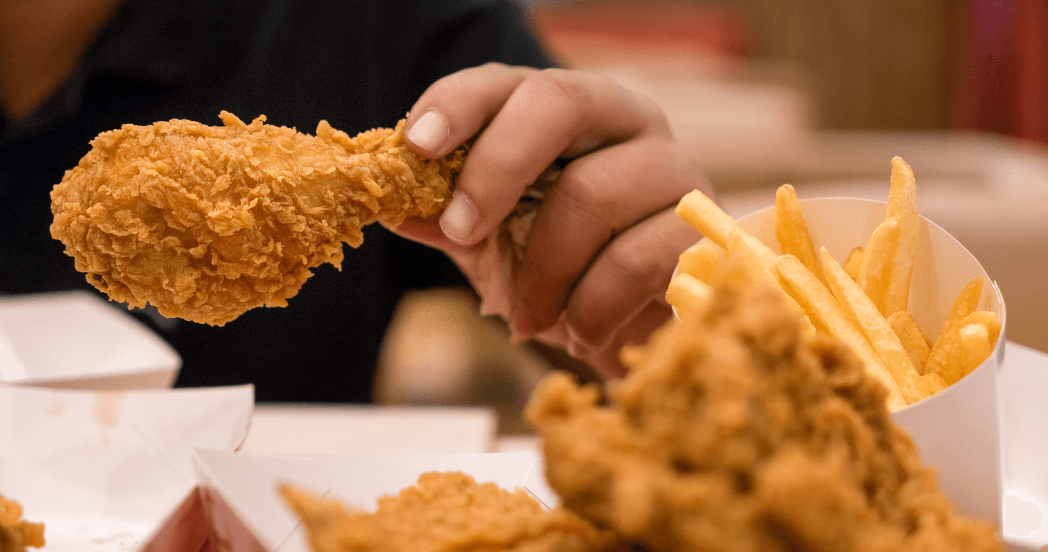 person eating fried chicken and fries