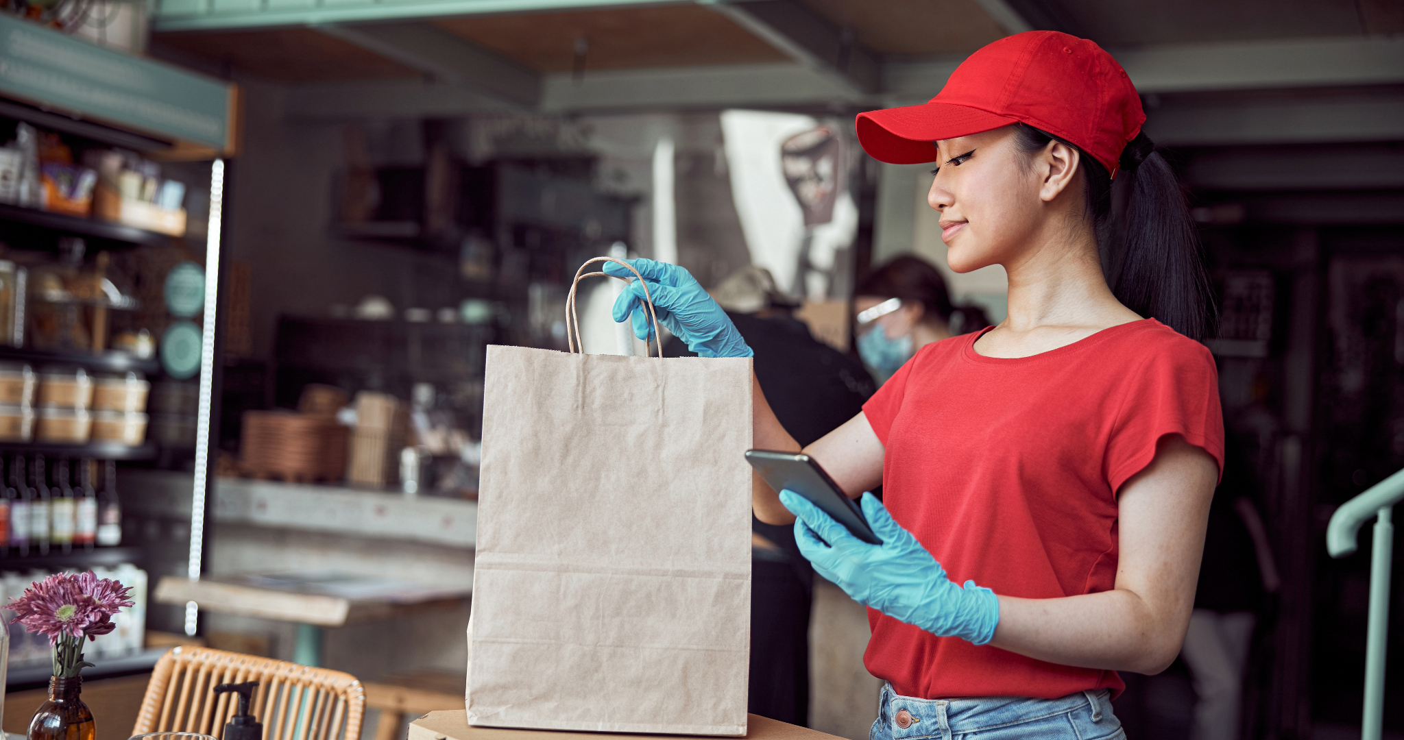 employee serving takeaway bag to customer